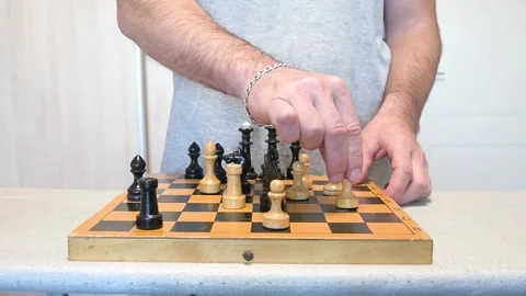 Man Making Strategic Move with White Pawn on Vintage Wooden Chessboard Close-up Stock Footage 333556124