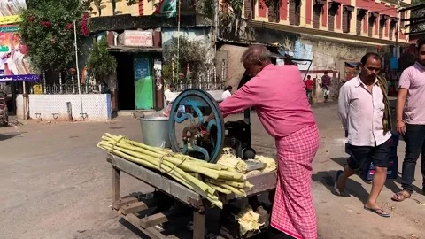 Man making sugarcane juice at a roadside cart in India Stock Footage 306683226