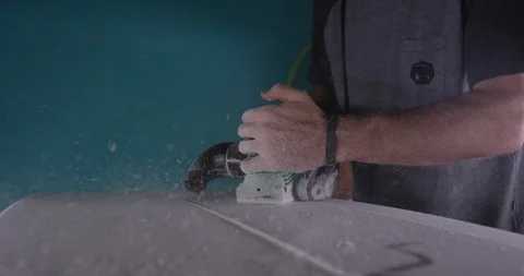 Man making a surfboard, using a surfboard planer Stock Footage 107641438