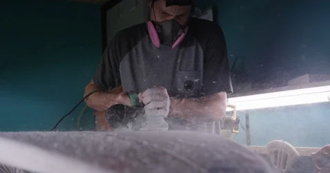 Man making a surfboard, using a surfboard planer Stock Footage 107641568