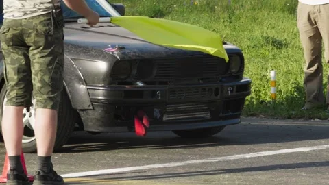 Man making swing with a yellow flag and cars breaks off from a start. Race begin 스톡 동영상 130389413