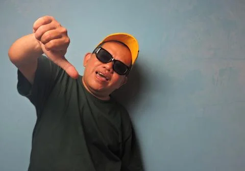 Man Making Thumbs Down Gesture Wearing Cap and Sunglasses Stock Photos