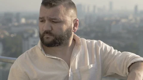 Man making toast with a beer to the camera and drinks it on the rooftop Stock Footage 93232638