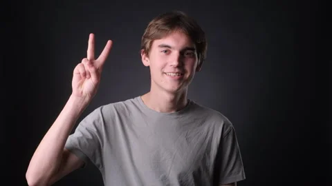 Man Making V Gesture on black Background Stock Footage 257476453