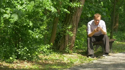 Man Making Video Call Waves His Hand Mobile Phone in Green Park Holding a Stock Footage 63811249
