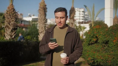Man making voice message or using virtual assistant app during stroll at the Stock Footage 277684812
