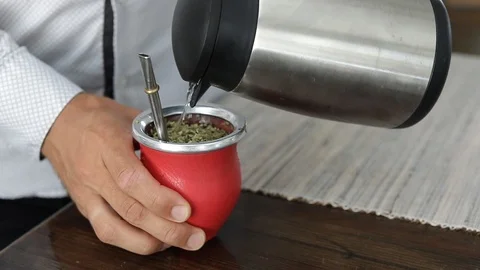 Man making yerba mate tea. Close up pouring hot water into traditional Mate cup. Stock Footage 127796277