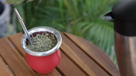 Man making yerba mate tea. Close up pouring hot water into traditional Mate cup. Stock Footage 127796278