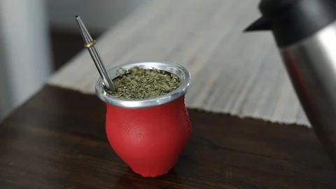 Man making yerba mate tea. Close up pouring hot water into traditional Mate cup. Stock Footage 127796303