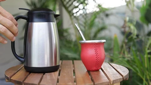 Man making yerba mate tea. Close up pouring hot water into traditional Mate cup. Stock Footage 127796349