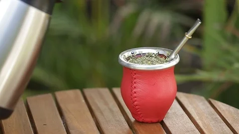 Man making yerba mate tea. Close up pouring hot water into traditional Mate cup. Stock Footage 127796361