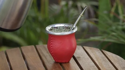Man making yerba mate tea. Close up pouring hot water into traditional Mate cup. Stock Footage 127796375
