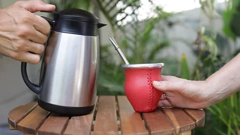 Man making yerba mate tea. Close up pouring hot water into traditional Mate cup. Stock Footage 127796379