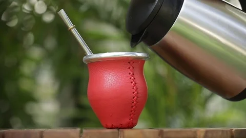 Man making yerba mate tea. Close up pouring hot water into traditional Mate cup. Stock Footage 127796409