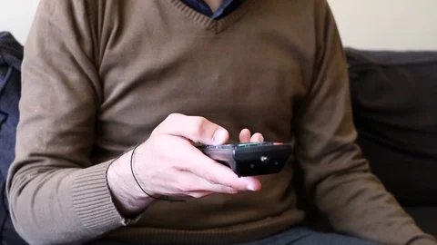 A man making zapping with a remote control on his couch Stock Footage 105721465