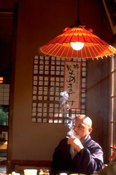 Man male bald smokes resteraunt by window kyoto Stock Photos