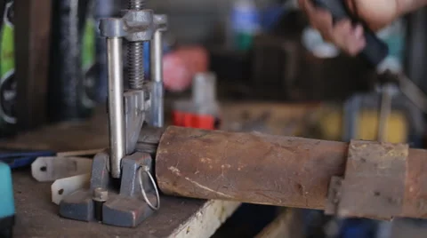 Man with a mallet to level the edge of the pipe in the workshop Stock Footage 54563851