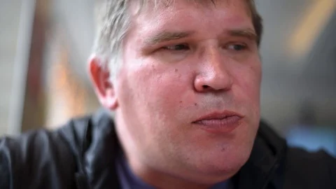 The man man eats the sandwiches hungrily biting off a big bite, drinking a drink Stock Footage 107308187