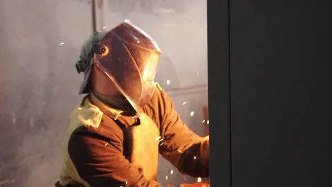 A man (man at the factory)  in a protective mask works with a welding machine. Stock Footage 196879519