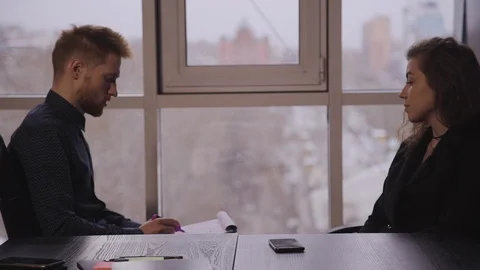 Man manager having job interview with young woman in suit and watching her Stock-Footage 119452376