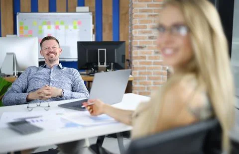 Man manager at work table sits smiling together with colleague 스톡 사진