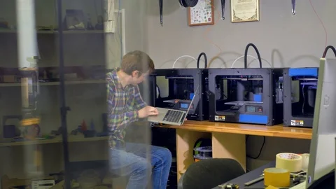 A man managing 3d-printing alone. Stock Footage