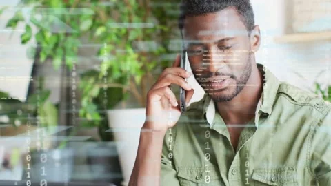 Man managing biz call, binary code overlaying after laptop input, pen noting, Stock Footage 333155509