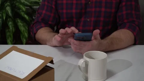 Man managing online return request using smartphone at home Stock Footage 305022260