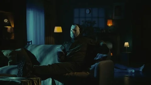 Man maniac sitting on the sofa in the room with smartphone watching something Stock Footage 249995671