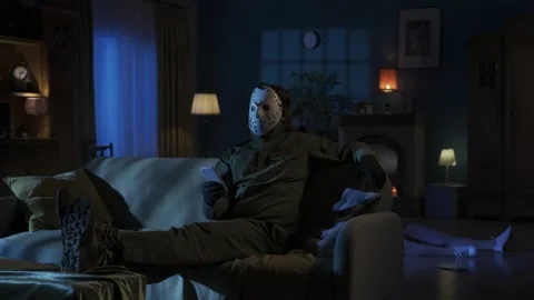 Man maniac sitting on the sofa in the room with smartphone watching something Stock Footage 250008827