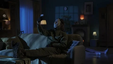 Man maniac sitting on the sofa in the someones living room, legs up on the table Stock Footage 250009185