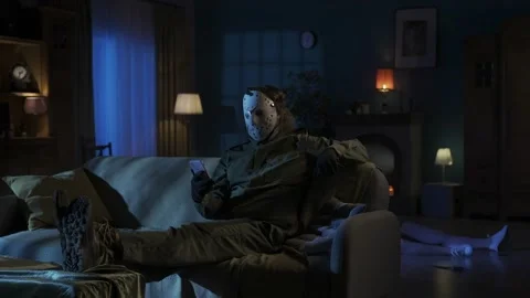 Man maniac sitting on the sofa in the someones living room, legs up on the table Stock Footage 250009278