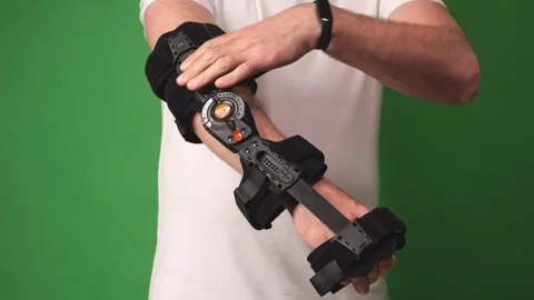 A man manipulates an elbow brace while explaining its use and bending his e.. Stock Footage 273041993