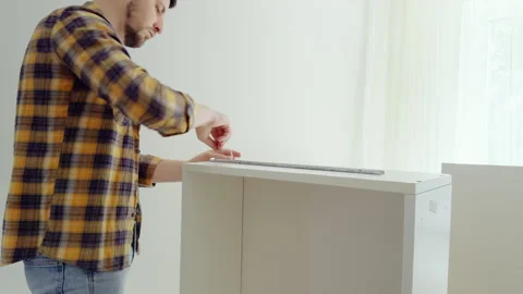 Man manually installs quality white furniture at home by himself. Young man Video stock 281291039