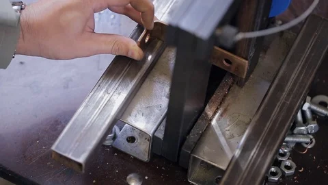 Man manually makes a metal bracket on the machine. Vidéo 78613413