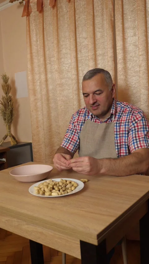 A man manually peels peanuts. Healthy eating. Stock Footage 306840488