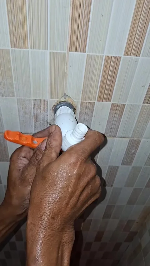 Man manually screws and installs a brand new white plastic water faucet wit.. Stock Footage 339574837
