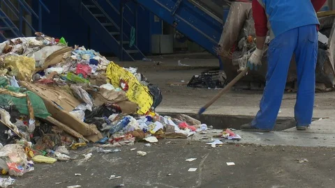 The man manually selects the waste at the landfill hall Stock Footage 121998903