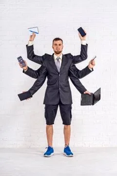 A man with many hands is standing in a jacket and shorts. Stock Photos