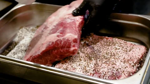 A man marinates red meat with spices before cooking it in a restaurant Stock Footage 264311520