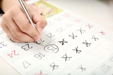 Man is marking 15 dates on the calendar with the pen Stock Photos