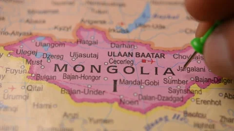 Man Marking Mongolia Location with Green Pin on Paper World Map Video stock 333571267
