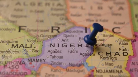 Man Marking Niger Location with Blue Pin on Paper World Map Stock Footage 333578167