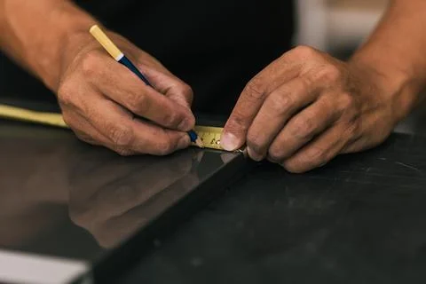 Man marking a surface using a meter in a workshop Stock Photos