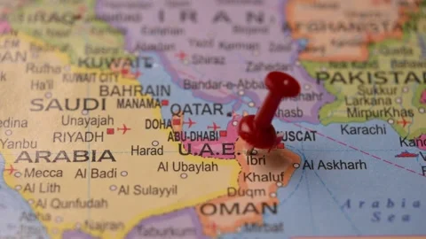 Man Marking UAE Location with Red Pin on Paper World Map Stock Footage 333574624