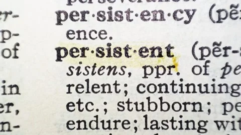 A man marks the definition from the word persistent on a printed page with a mar Stock Footage 297282721