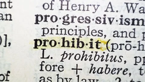 A man marks the definition from the word prohibit on a printed page with a marke Stock Footage 297282725
