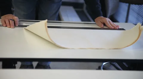 Man marks sheets of paper before cutting Stock Footage 56661075