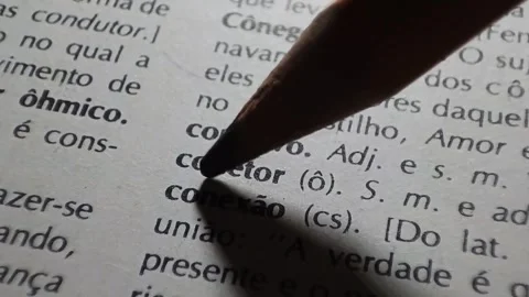 A man marks the word connection definition in portuguese  on a printed page with Stock Footage 297276897