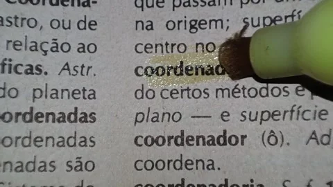 A man marks the word coordinated definition in portuguese  on a printed page wit Stock Footage 297276927